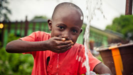 child drinking water by hand